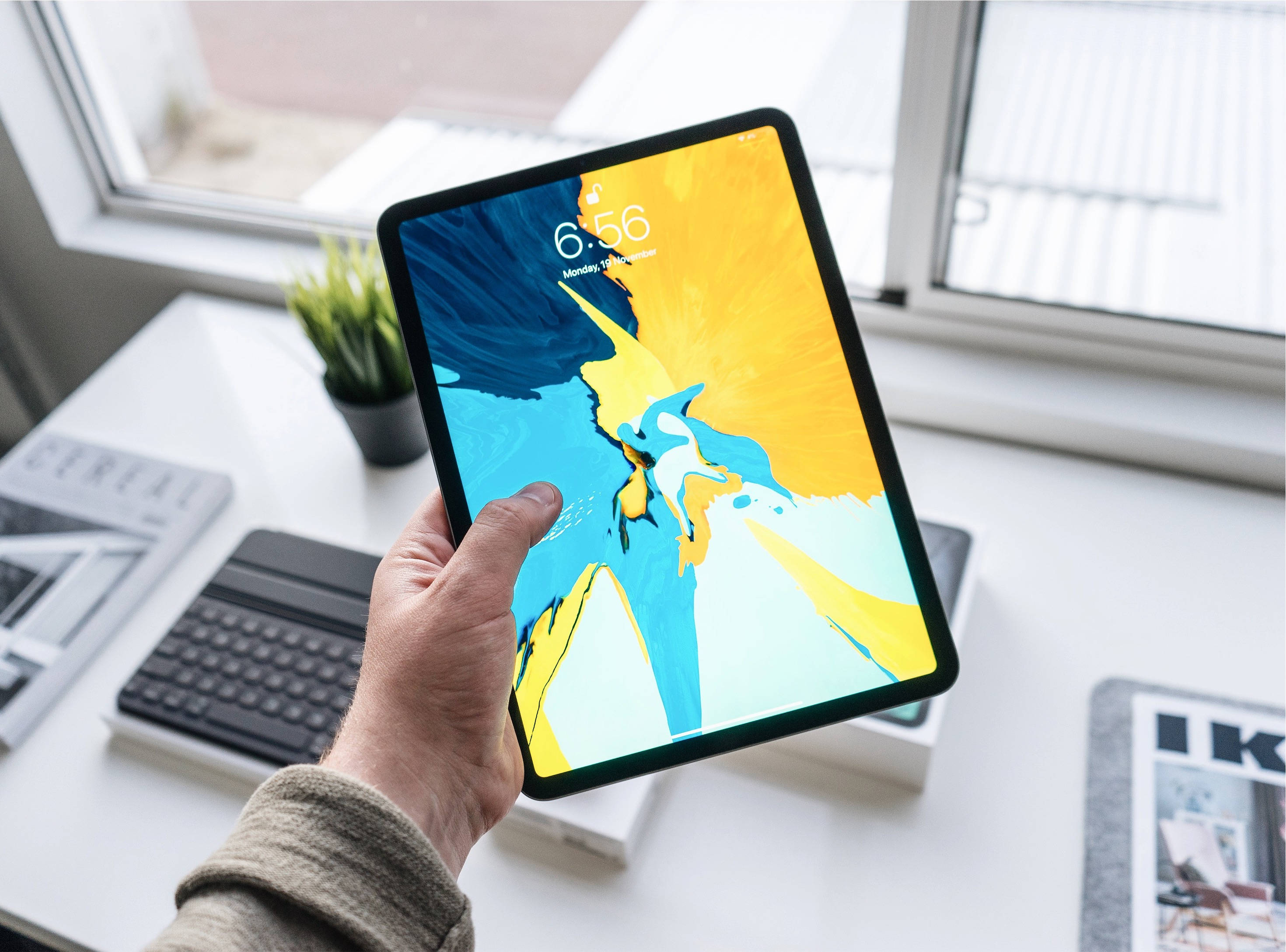 手持Apple iPad Pro的人 壁纸