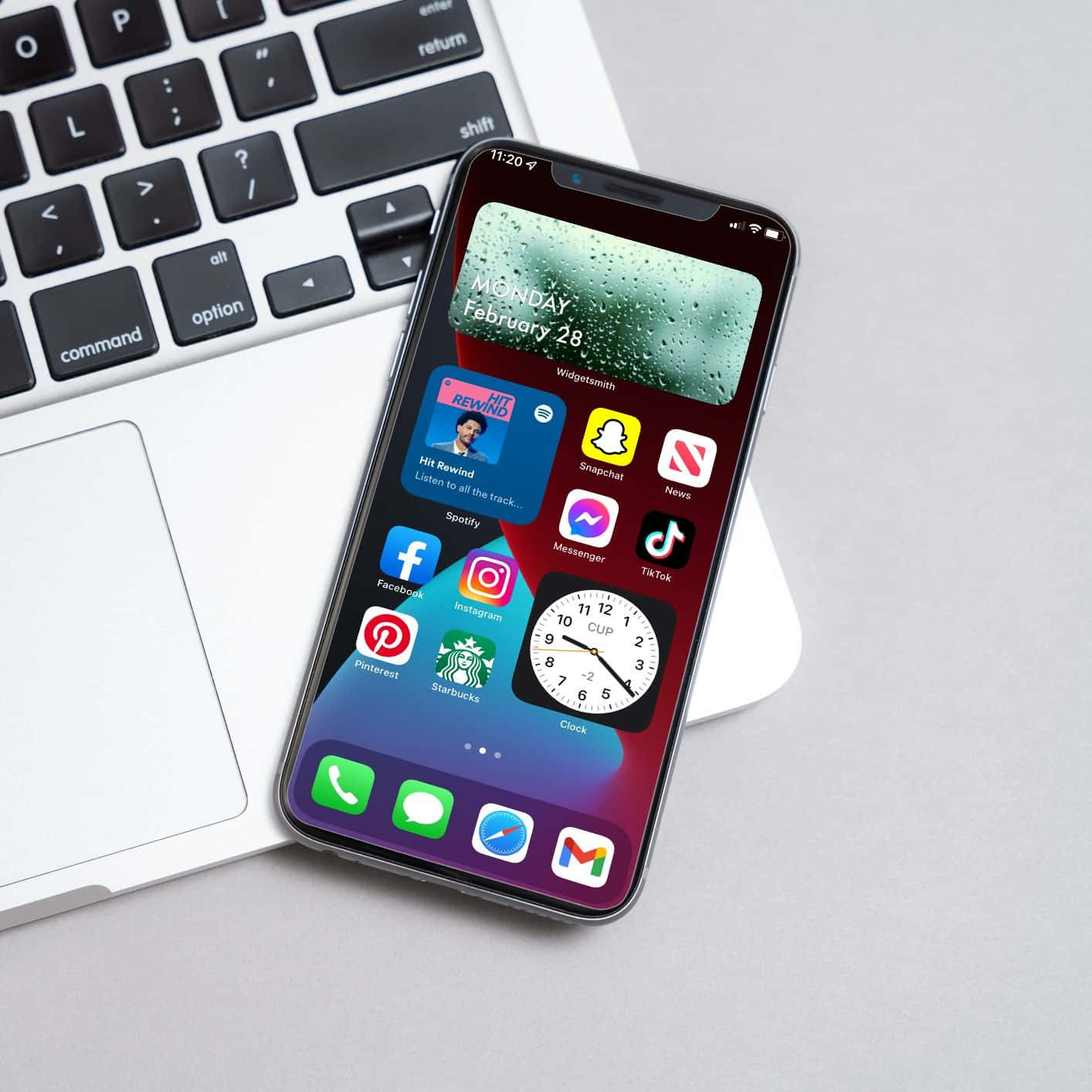 iPhone XR 与笔记本电脑并排摆放，屏幕上显示应用图标 壁纸