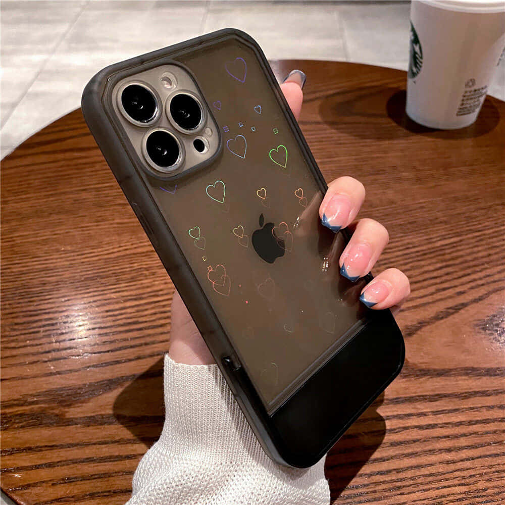 一位手持带有爱心图案iPhone 11手机壳的女性 壁纸