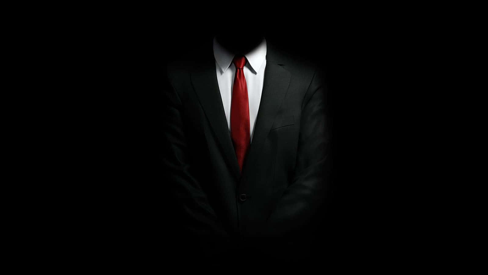 一名身着西装领带的男子站在黑暗中 壁纸