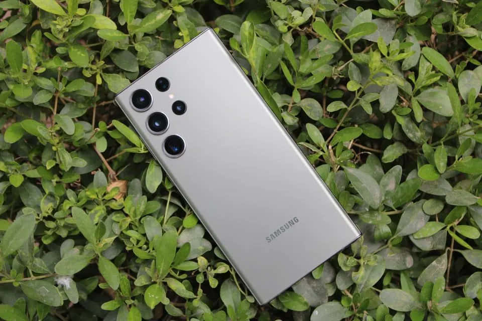三星S23 Ultra手机静置于绿色叶片背景上 壁纸