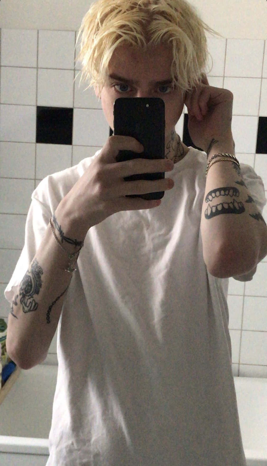 侧身站立的男孩，身着都市风格服饰与白色运动鞋 壁纸