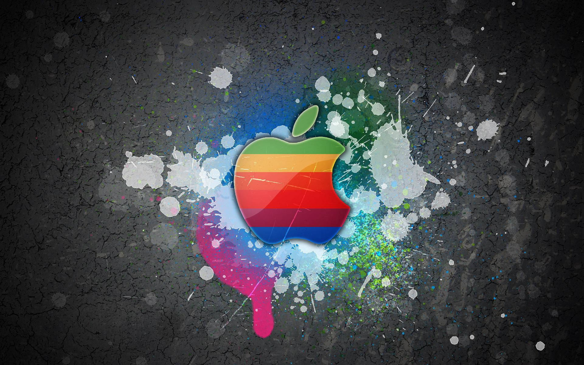 苹果Macbook标志在灰色墙壁上的酷炫彩色壁纸，带有油漆飞溅效果