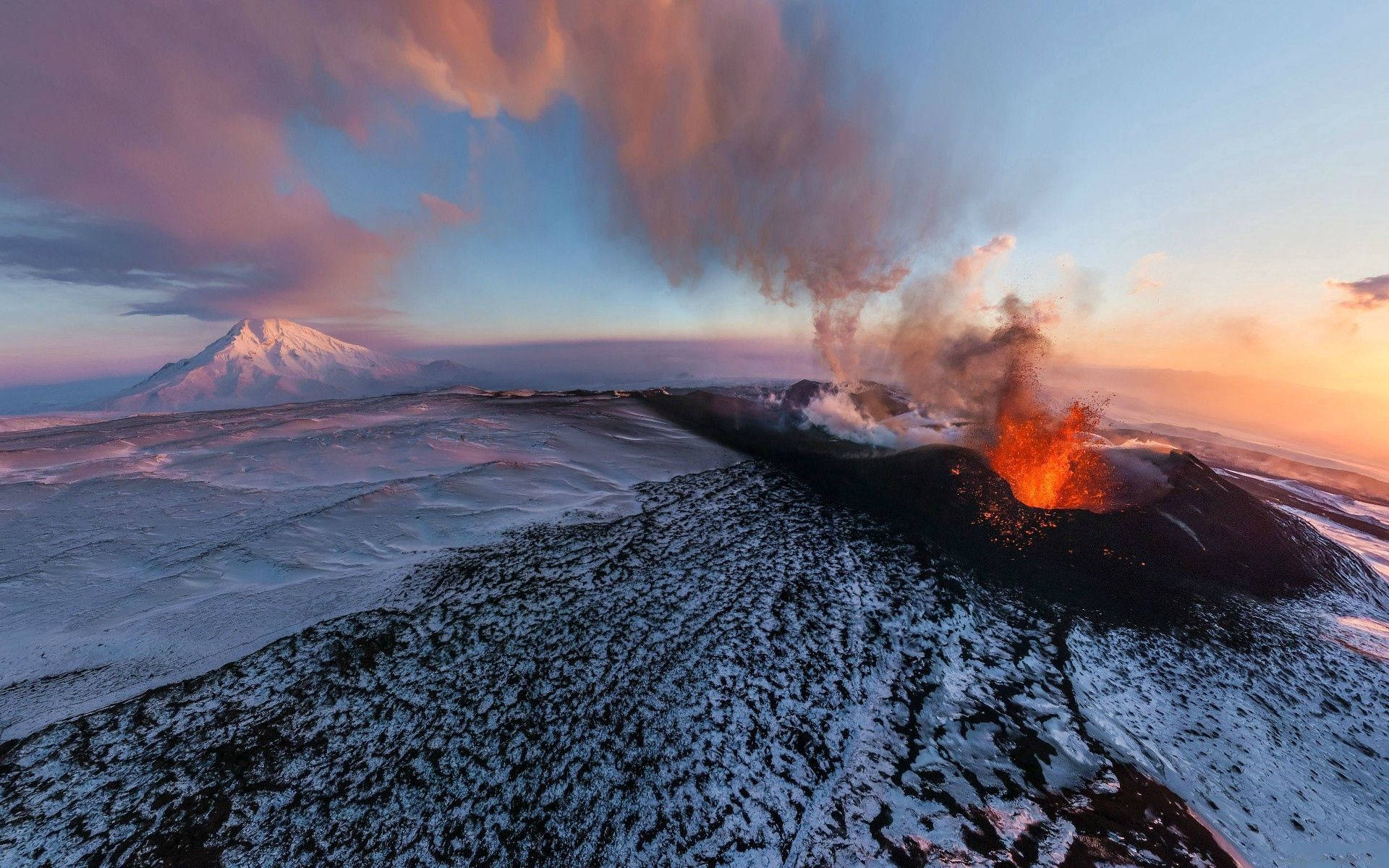 火山在日落时喷发烟雾和火焰。