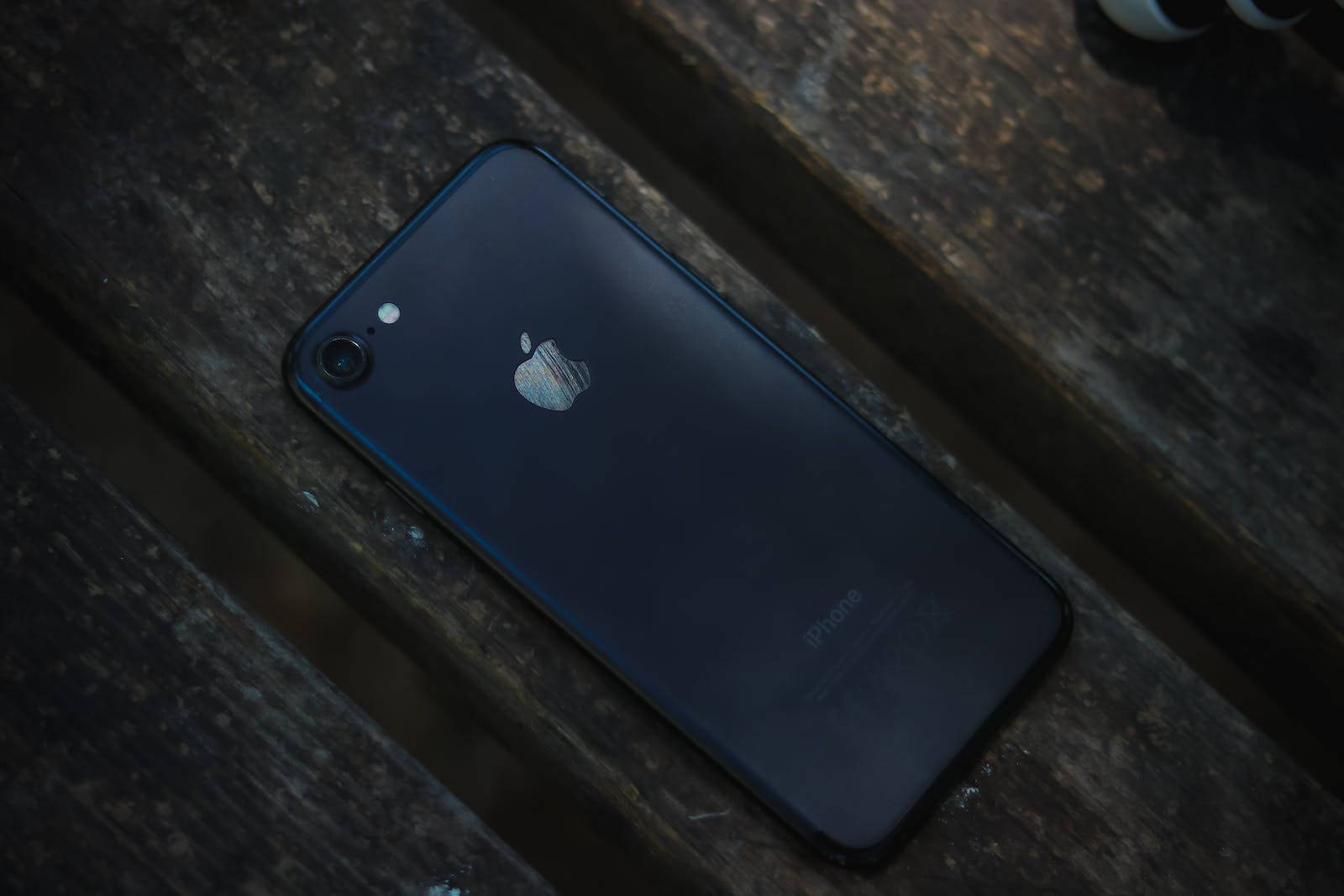 木质桌面上的黑色iPhone 7 壁纸
