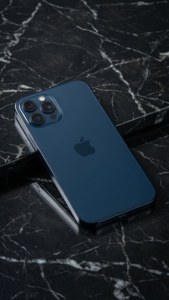 午夜蓝iPhone 17置于大理石上，简约工作室拍摄。