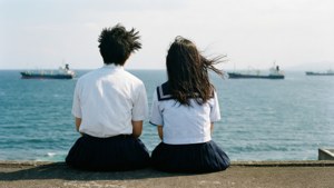 拓和里佳子坐在学校屋顶上俯瞰大海，出自《海潮之声》。 — 海浪 壁纸