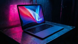赛博朋克风格的MacBook，在暗室中呈现霓虹反射效果。